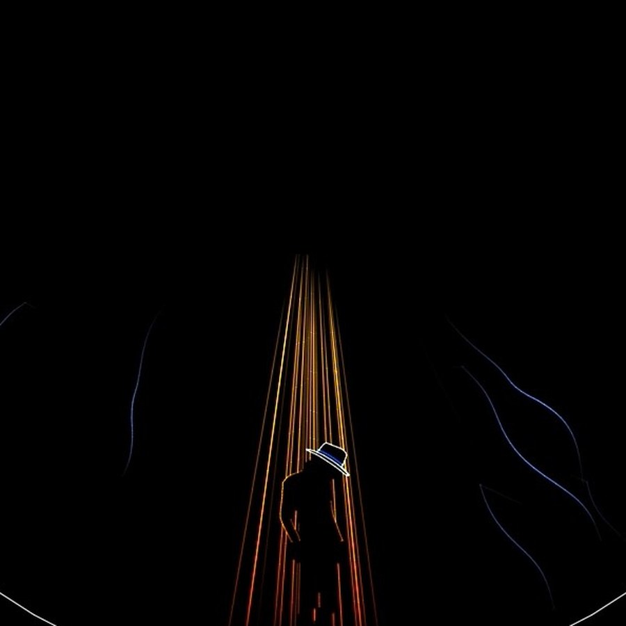 Figure in a fedora beneath descending laser beams, from a music show